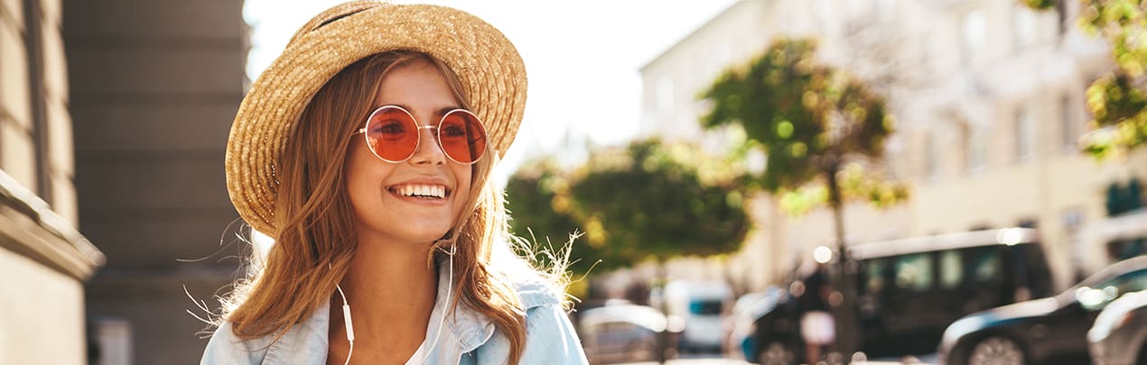 woman with sunglasses and hat smiling