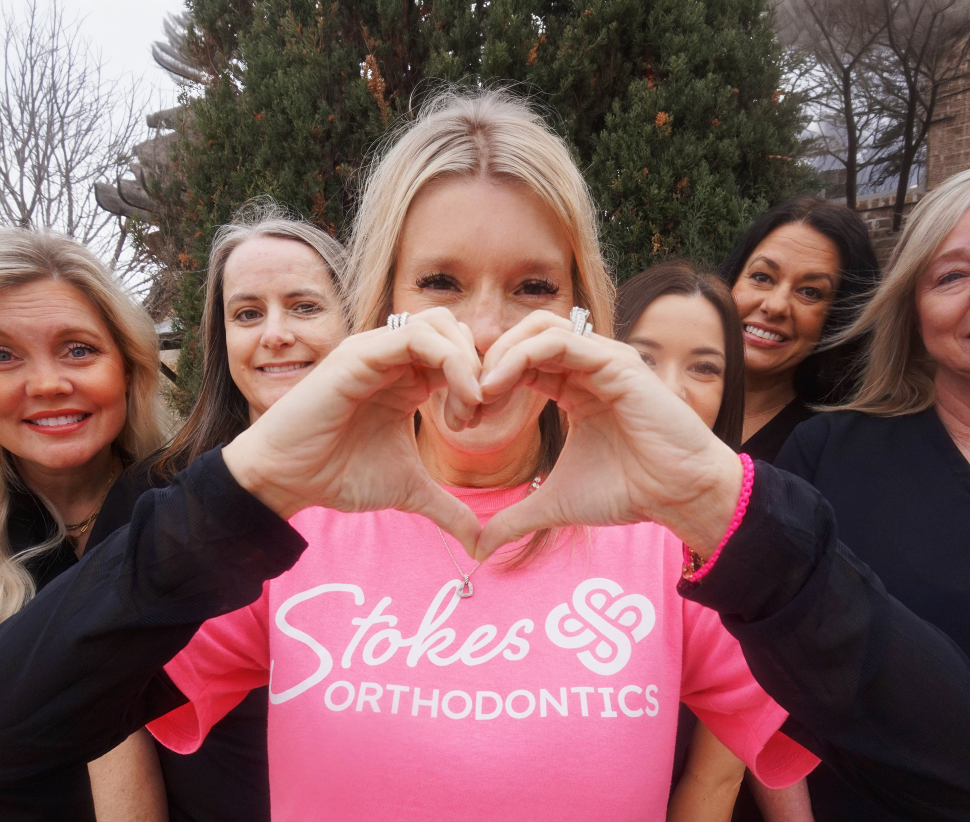 Dr Stokes Making A Heart Shape With Her Hands In Front Of Her Crew